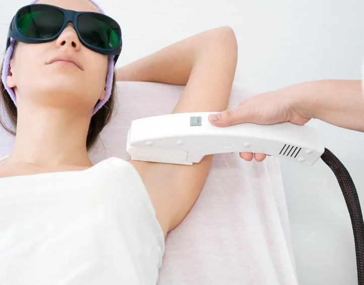 Client in protective eyewear during a laser treatment on the arm
