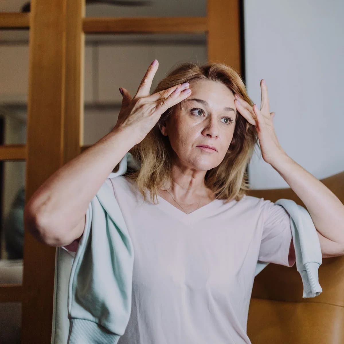Mature woman gently touching her face during her skincare routine